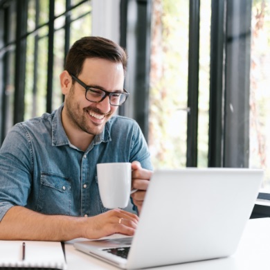 Man in front of his laptop smiling