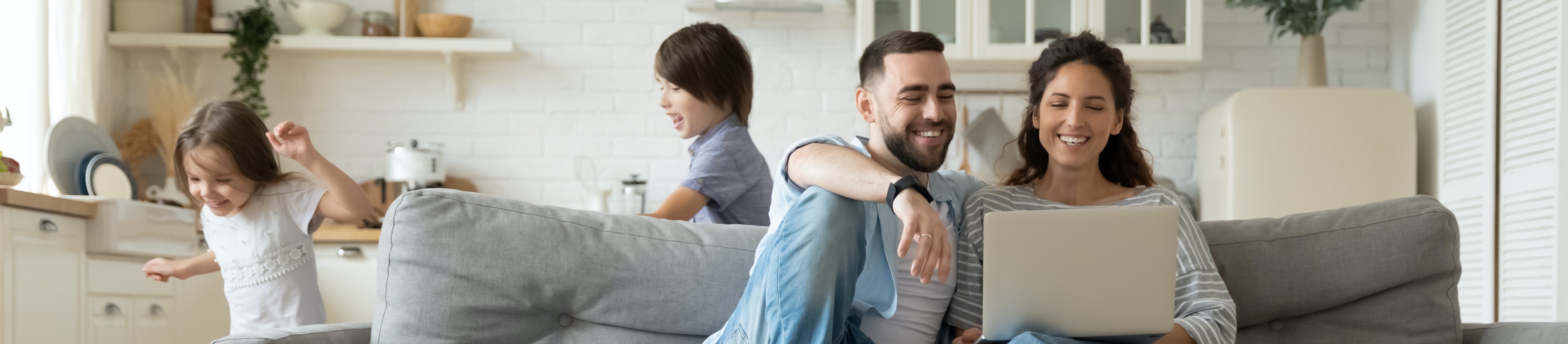 young Canadian family in living room finding life insurance solutions online