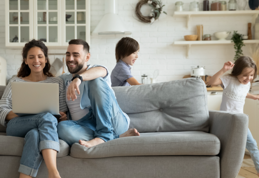 young Canadian family in living room finding life insurance solutions online